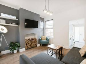a living room with a couch and a fireplace at Cambridge House - Modern 2 Bedroom House, Close to Luton Airport & Town Centre in Luton