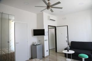een woonkamer met een bank en een plafondventilator bij Ville Vesuviane in San Giorgio a Cremano +51 foto's