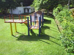 un parc avec une aire de jeux sur gazon dans l'établissement Parque Hotel Morro Azul - a 12 km do Parque dos Dinossauros, à Morro Azul