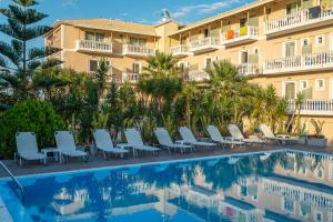a hotel with a swimming pool with chairs and a building at Zakynthos Hotel in Tsilivi
