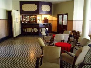 a room with a bar with chairs and a table at Parque Hotel Morro Azul - a 12 km do Parque dos Dinossauros in Morro Azul
