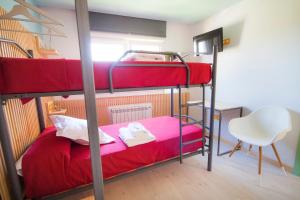 Un dormitorio con dos literas y una silla. en Pension Restaurante Casa Camiño, en Palas de Rei 