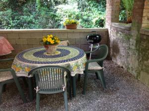 una mesa con dos sillas y un jarrón de flores. en Villa Morante, en Borgo a Mozzano