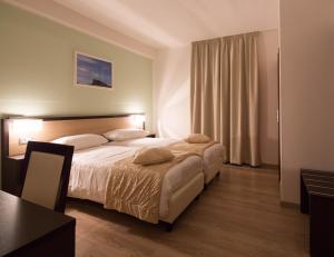 a bedroom with a large bed with a table and a table at Albergo Ristorante Bismantova in Castelnovo neʼ Monti