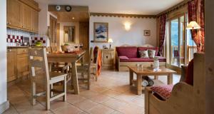 a kitchen and living room with a table and a couch at CGH Résidences & Spas La Ferme Du Val Claret in Tignes