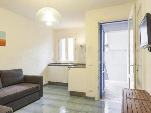 WeLive Marettimo - luxury loft في ماريتيمو: غرفة معيشة مع أريكة ومطبخ