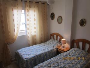 ein Schlafzimmer mit zwei Betten und einem Fenster in der Unterkunft los locos San Pascual in Torrevieja