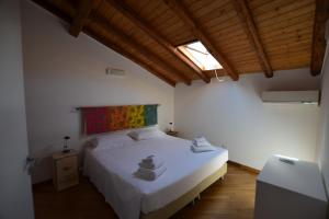 um quarto com uma cama branca e uma pintura na parede em Tambù Apartments em Catânia