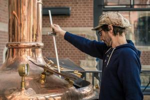 a man in a hat is stirring a pot at Craft Beer Central Hotel in Gdańsk