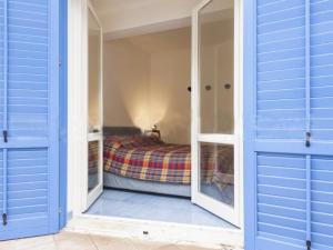WeLive Marettimo - luxury loft في ماريتيمو: غرفة نوم بأبواب زرقاء وسرير فيها