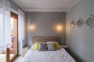 um quarto com uma cama com almofadas amarelas e cinzentas em udanypobyt Apartamenty Skocznia em Zakopane