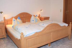 ボーデンマイスにあるFW Bodenmaiser Blickの木製ベッド(青と白のシーツ、枕付)