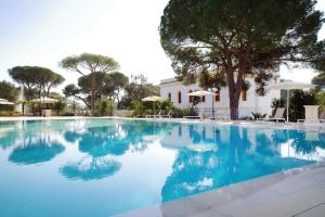 a large swimming pool with blue water at Le scuderie di Villa Ravenna Luxury House in Sannicola