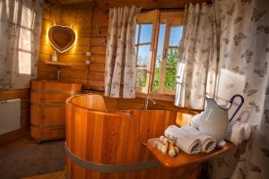 a bathroom with a wooden tub with a vase and towels at Ecolodge Langhe in Cherasco