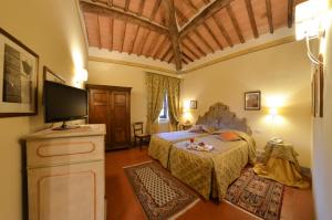 a bedroom with a bed and a flat screen tv at Villa Borgo San Pietro in Cortona