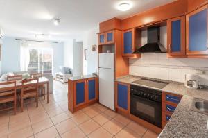 a kitchen with blue cabinets and a dining room at Bolitx in Oliva