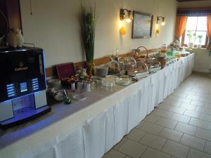 una linea lunga a buffet con tavoli bianchi con cibo di Gästehaus Zur schönen Aussicht a Wies