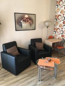 - un salon avec deux chaises et une table dans l'établissement Master Apartments, à Belgrade
