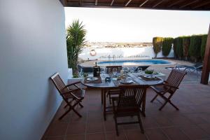 een terras met een tafel en stoelen en een zwembad bij Villa Benita in Playa Blanca