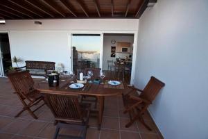 een houten tafel en stoelen in de woonkamer bij Villa Benita in Playa Blanca