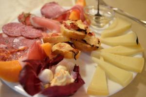 a plate of food with cheese and other foods at Villa Borgo San Pietro in Cortona