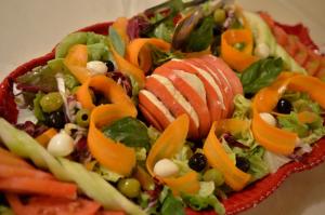 a salad with fruit and vegetables in a red bowl at Villa Borgo San Pietro in Cortona