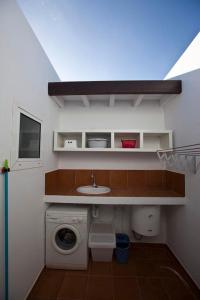 baño pequeño con lavadora y lavamanos en Villa Benita, en Playa Blanca