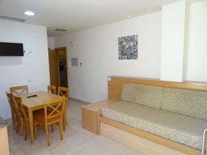 a room with a bed and a table and a dining room at Apartamentos Selvapark in Lloret de Mar