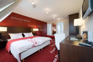 a bedroom with a bed and a desk with a computer at Hotel Landgasthof Bären in Trossingen