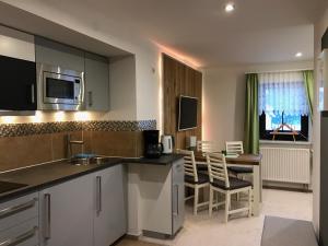 a kitchen with a counter and a table and chairs at Pension Schanzenblick in Kurort Oberwiesenthal