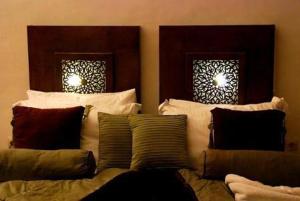 Bett mit Kissen darauf in einem Zimmer in der Unterkunft Riad Chayma Marrakech in Marrakesch