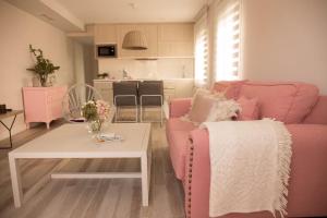 sala de estar con sofá rosa y mesa en Apartamento El Balcon de la Muralla, en Córdoba