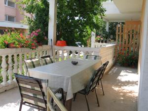 - une table et des chaises sur une terrasse fleurie dans l'établissement Apartment Mime Blata, à Vodice