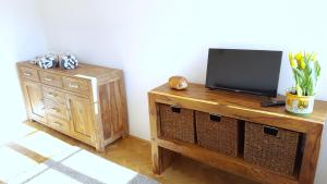 a television on a wooden stand next to a cabinet at Apartmány u náměstí in Broumov