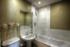 a bathroom with a sink and a mirror and a tub at Dunster Castle Hotel in Dunster +37 photos