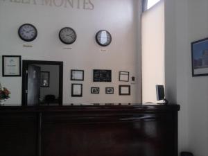 una sala de espera con relojes en la pared en Hotel Villa Montes, en Ezequiel Montes