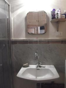 サンタンドレーア・アポストロ・デッロ・イオーニオにあるCasa Mariaのバスルーム(鏡付き白い洗面台付)