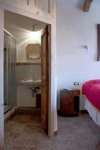 サンタンドレーア・アポストロ・デッロ・イオーニオにあるCasa Mariaのバスルーム(シンク、ベッド、鏡付)