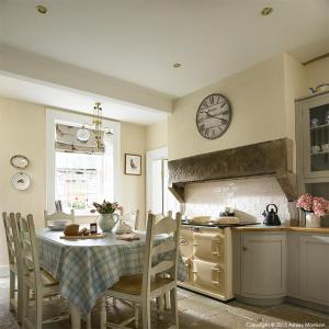 a kitchen with a table and a clock on the wall at The Brook in Enniskillen