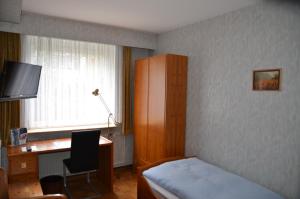 a bedroom with a bed and a desk and a window at Hotel Waldersee in Hannover