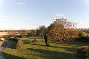 a park with trees and bushes and a road at La Demeure du Castel in Rospez