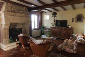 a living room with a fireplace and chairs and a tv at La Demeure du Castel in Rospez