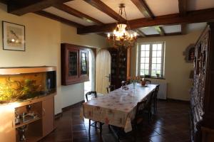 a dining room with a table and a fish tank at La Demeure du Castel in Rospez