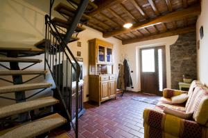 Habitación con escalera y sala de estar con sofá. en Casa Macina, en Borgo a Mozzano