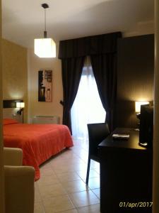 a bedroom with a red bed and a window at La Terrazza B&B in Rossano