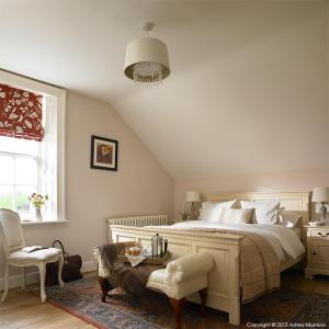 a bedroom with a bed and a chair and a window at The Brook in Enniskillen