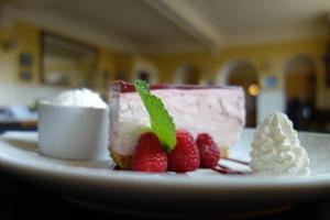 a piece of cake on a plate with strawberries at Kilmarnock Arms Hotel in Cruden Bay