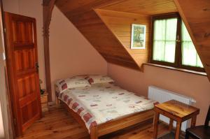 a bedroom with a bed with a wooden ceiling at Pensjonat Dolina Wierzby in Olsztyn