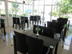 a dining room with a table and chairs and windows at โรงแรมฟ้าพราวฝน Fah Proud Fon Hotel in Nakhon Ratchasima