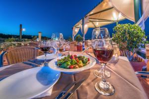 a table with wine glasses and a plate of food at Strada Marina Hotel in Zakynthos